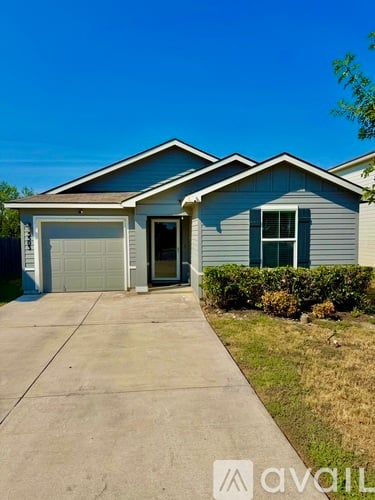 A two-story house with a garage and a driveway.