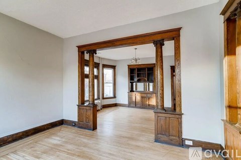 A room with wooden floors and furniture, and a large mirror on the wall.