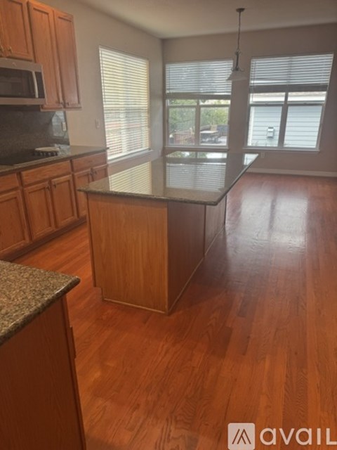 A kitchen with wooden cabinets and a granite countertop.