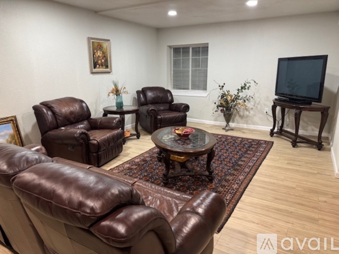 A living room with brown leather furniture and a flat screen TV.