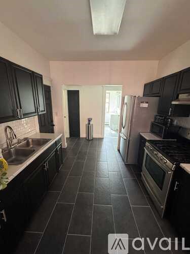 A kitchen with black cabinets and appliances.
