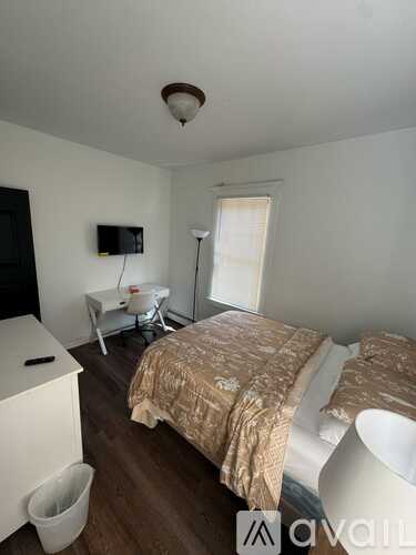 A bedroom with a bed, a chair, and a television.