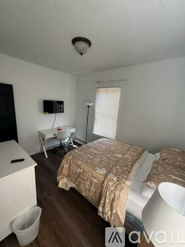 A bedroom with a bed, a chair, and a television.