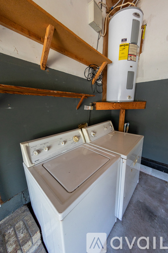 A washing machine and a water heater are in a small room.