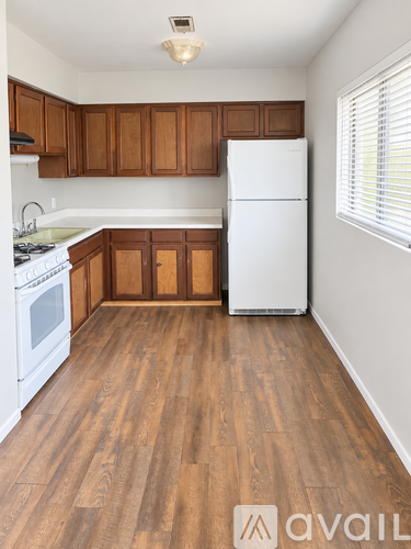 A kitchen with wooden cabinets and a white fridge.