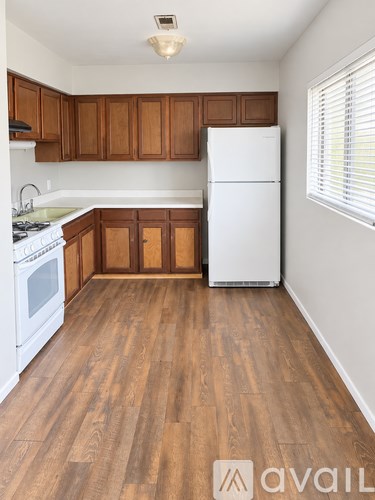 A kitchen with wooden cabinets and a white fridge.