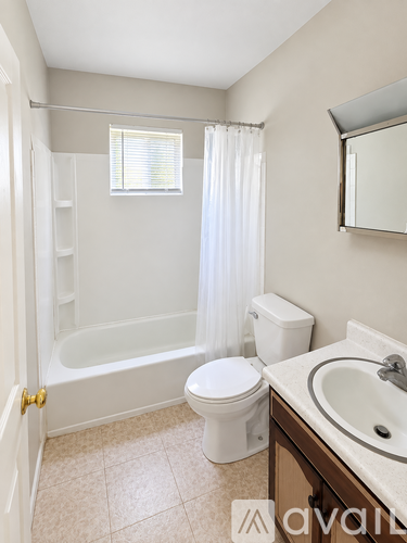 A bathroom with a toilet, sink, and bathtub.