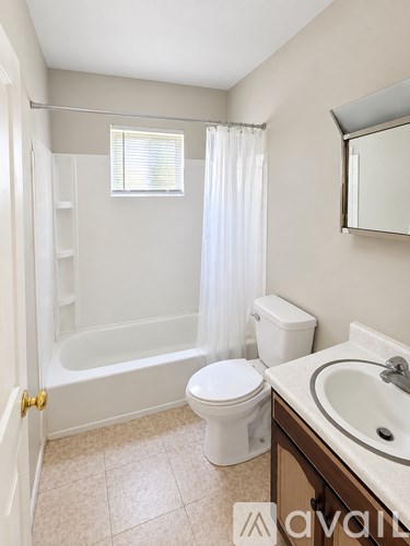 A bathroom with a toilet, sink, and bathtub.