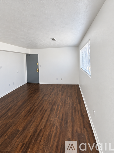 A room with wooden floors and a grey door.