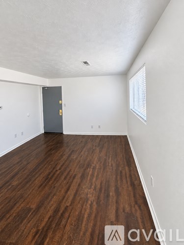 A room with wooden floors and a grey door.