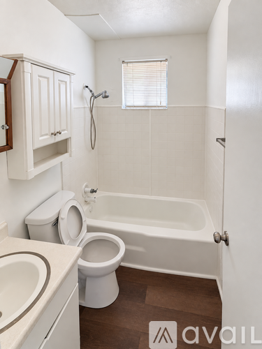 A white bathroom with a toilet, sink, and bathtub.