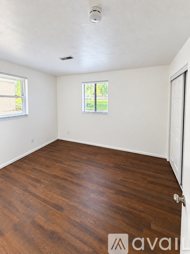 A room with wooden flooring and a window.