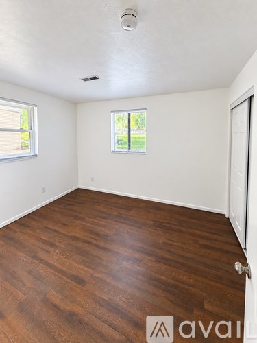 A room with wooden flooring and a window.