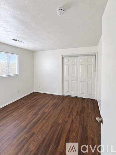 A room with wooden floors and a white door.