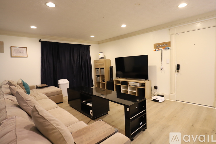 A living room with a black curtain and a flat screen TV.