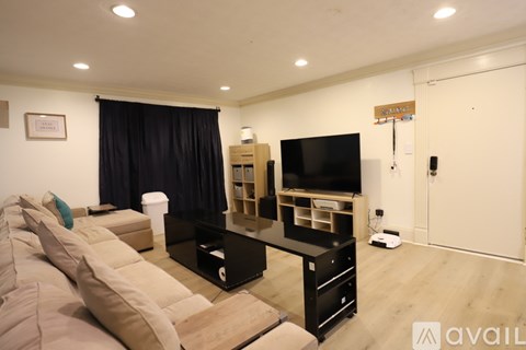 A living room with a black curtain and a flat screen TV.