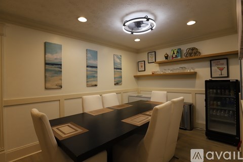 A conference room with a long table and chairs, a wine rack, and framed pictures on the wall.