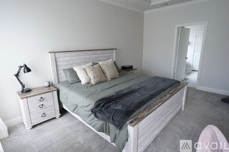 A bedroom with a bed, nightstand, and lamp.