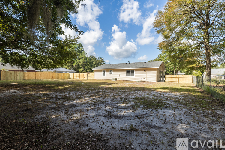 A large, open, muddy yard with a building in the background.