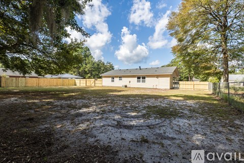 A large, open, muddy yard with a building in the background.