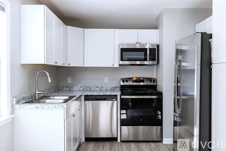 A kitchen with white cabinets and stainless steel appliances.