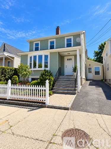 A house with a white picket fence in front.