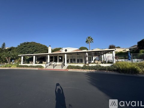 A building with a white roof and a sign that says "AVAIL" in front of it.