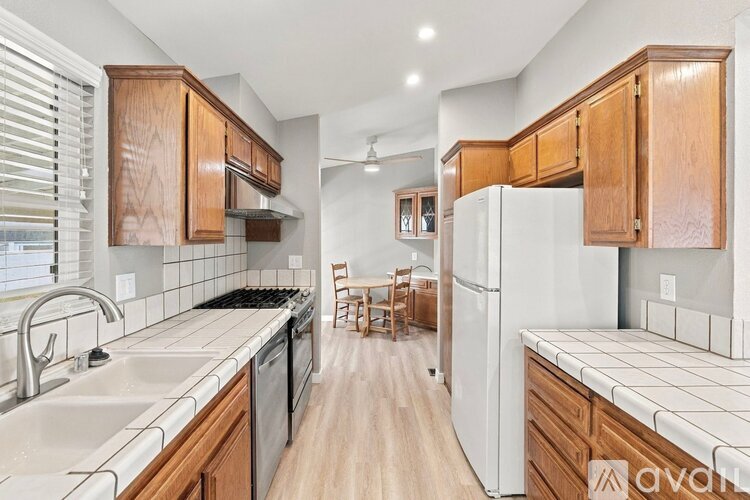 A kitchen with wooden cabinets and a white refrigerator.