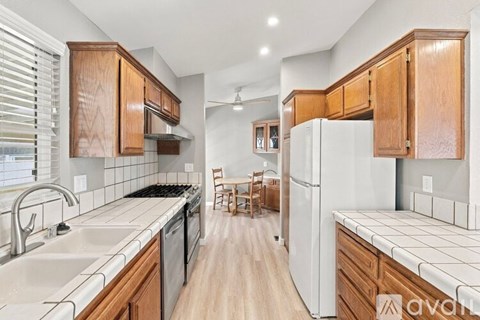 A kitchen with wooden cabinets and a white refrigerator.