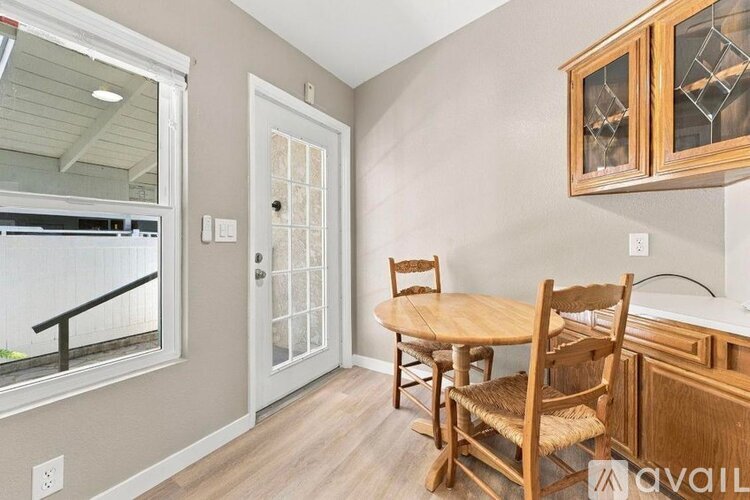 A dining room with a wooden table and chairs.