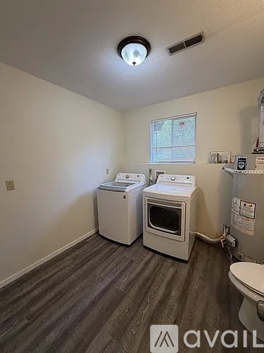 A room with a toilet, a washing machine, and a dryer.