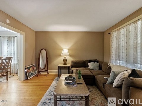 A living room with a couch, a chair, a coffee table, and a lamp.