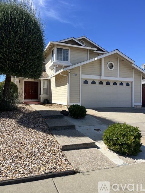 A house with a brown door and a garage door is for sale.