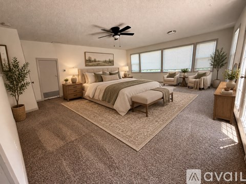 A bedroom with a large bed and a ceiling fan.