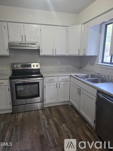A kitchen with white cabinets and a stove top oven.