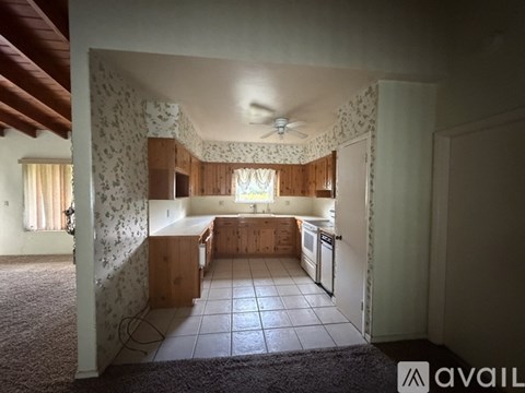 A kitchen with wooden cabinets and a ceiling fan.