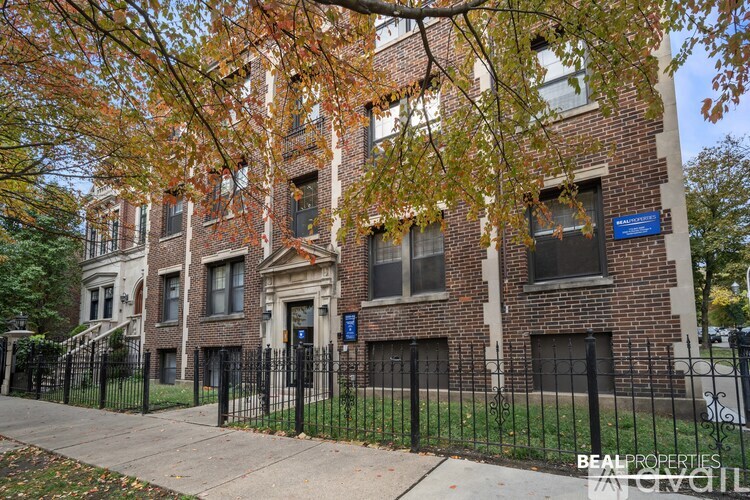 A brick building with a black fence in front.