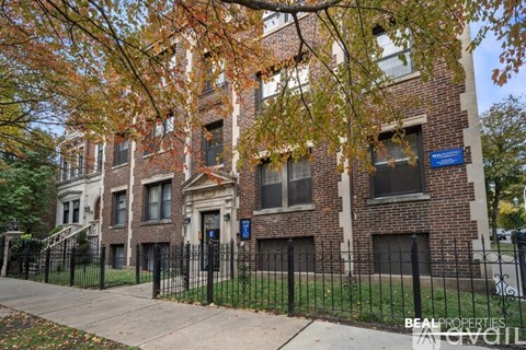A brick building with a black fence in front.
