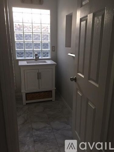 A bathroom with a sink and a window.
