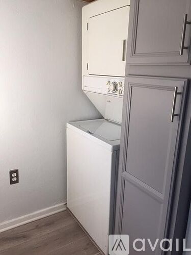 A white oven and microwave are built into a cabinet in a kitchen.