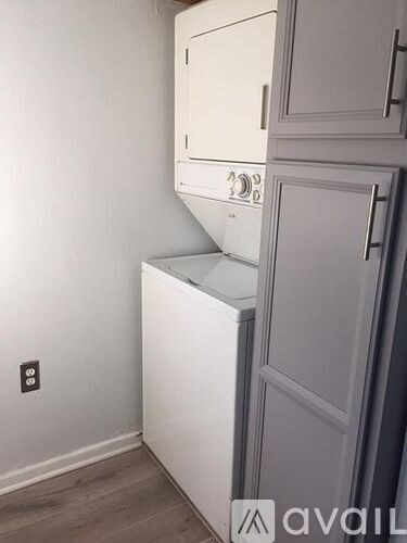 A white oven and microwave are built into a cabinet in a kitchen.