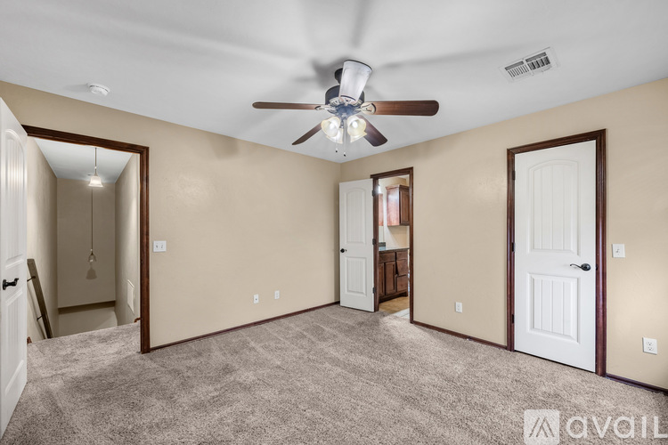 A spacious room with a ceiling fan and carpeted floor.