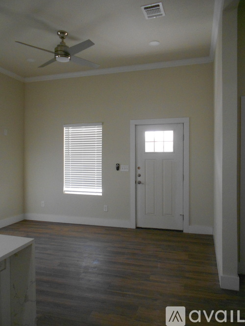 A room with a ceiling fan and a door.