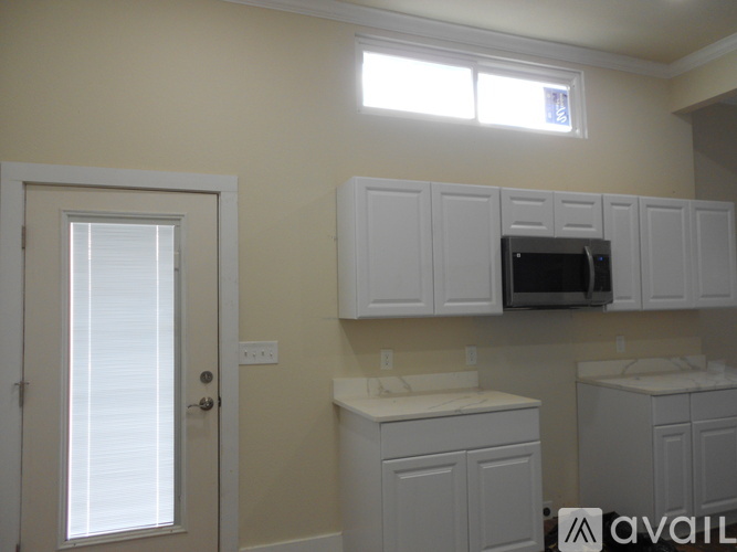 A kitchen with white cabinets and appliances.