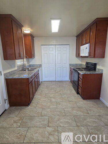 A kitchen with brown cabinets and a white door.