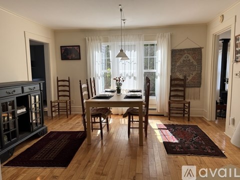 A dining room with a wooden table and chairs.