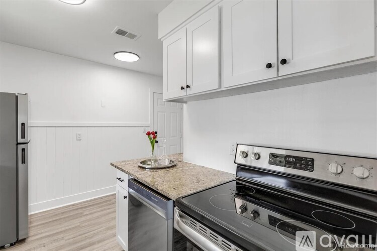 A kitchen with a stove top oven and a refrigerator.