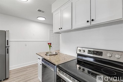 A kitchen with a stove top oven and a refrigerator.