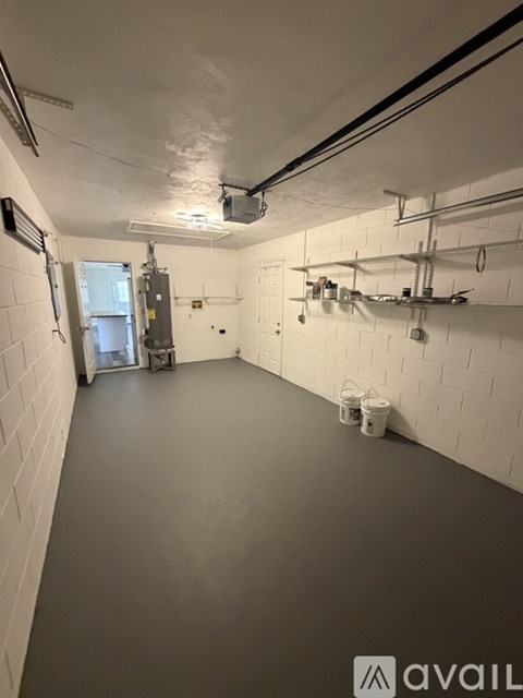 A spacious room with white walls and a grey floor.