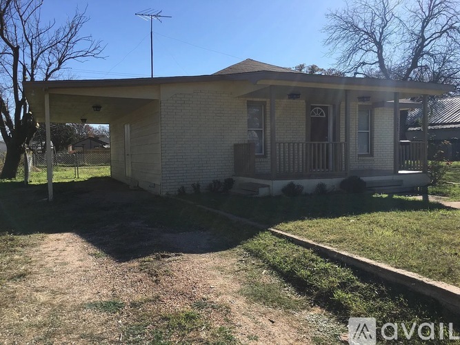A house with a front porch and a small yard.